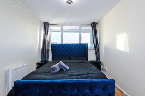 a blue bed in a small room with a window at 1BR Apartment By Kammili Properties - Near City Centre, Universities & Hospital in Manchester