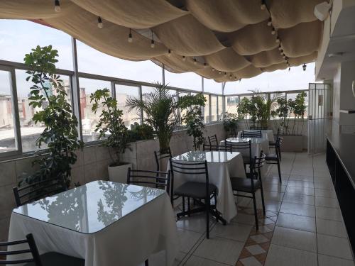 a restaurant with tables and chairs and windows at TERRAMISTICA CENTRO BY Casa Consuelo in Arequipa