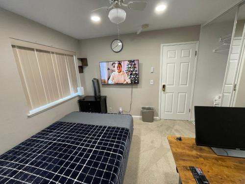 a bedroom with a bed and a tv on the wall at Room R1 with tempurpedic mattress and top facilities in San Jose