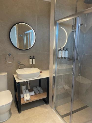 a bathroom with a shower and a sink and a mirror at R Lapsi Guesthouse in Siġġiewi