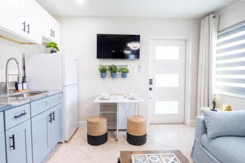 Una cocina con un refrigerador blanco y una mesa. en Longwood Private Suite - Near Orlando - Modern, Private Entrance, Fast WiFi, en Orlando