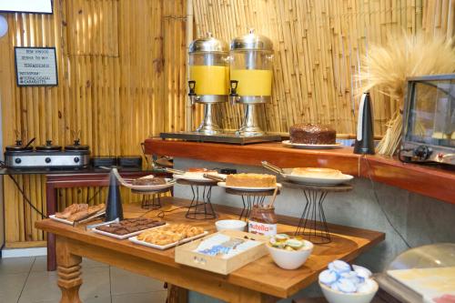 una mesa con diferentes tipos de alimentos. en Icaraí Suítes, en Niterói