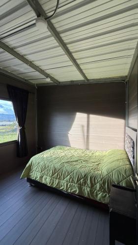 a bedroom with a bed in a room with a window at Cabaña Susurro de Susata in Nemocón