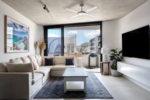 a living room with a couch and a flat screen tv at Premium Bondi Beach 2 Bedroom with Beach view and parking in Sydney