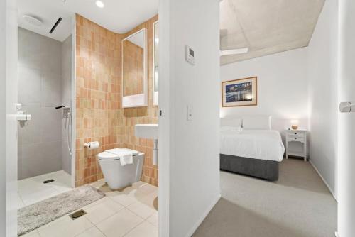 a bedroom with a bed and a bathroom with a shower at Premium Bondi Beach 2 Bedroom with Beach view and parking in Sydney