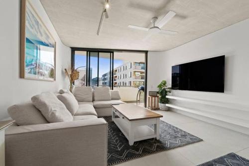 a living room with a couch and a flat screen tv at Premium Bondi Beach 2 Bedroom with Beach view and parking in Sydney