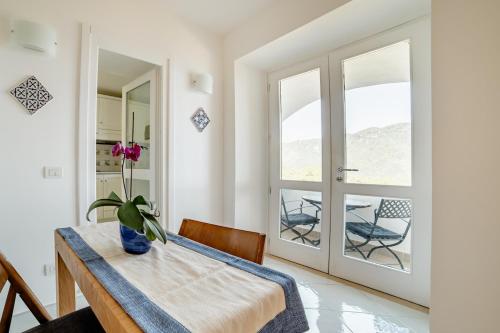 a dining room with a table with a flower on it at La Dolce Vita Ravello - Exclusive Family & Group Villa with 4 Apartments, 5 Bedrooms in Ravello