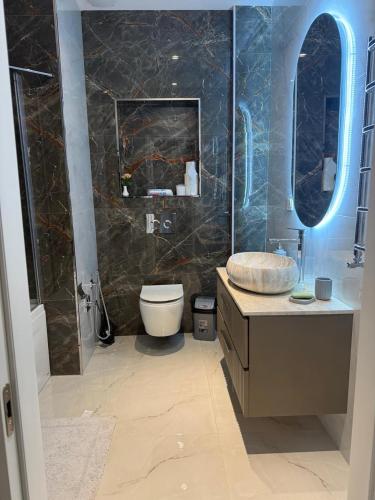 łazienka z toaletą, umywalką i lustrem w obiekcie White City Apartment w mieście Baku