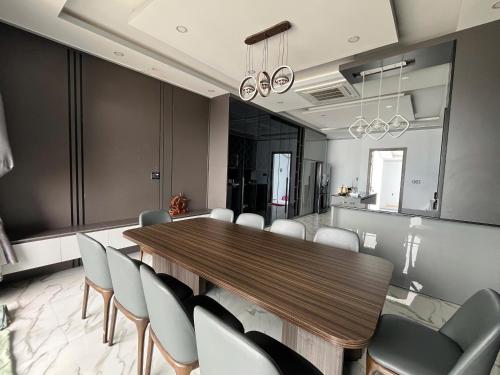 a dining room with a wooden table and chairs at Thiên long homestay in Kinh Dinh