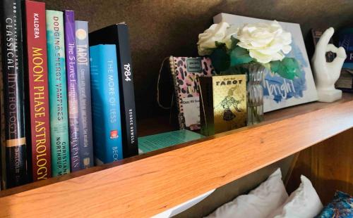 a book shelf with books and a vase of flowers at ZenDen Rv by The Sea in Los Osos in San Luis Obispo