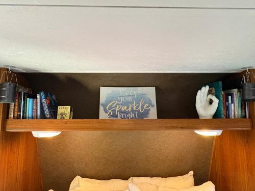 a shelf above a bed with books on it at ZenDen Rv by The Sea in Los Osos in San Luis Obispo