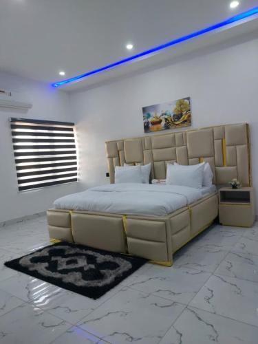 a bedroom with a large bed with a large headboard at 2 bedroom Apartment Lekki Ovation Terrace and extra room in Lekki