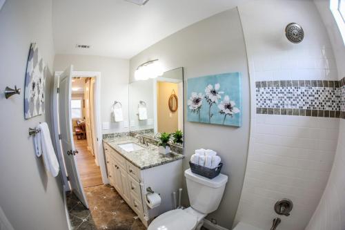 ein Badezimmer mit Toilette, Waschbecken und Spiegel in der Unterkunft Destination #37 in Fullerton