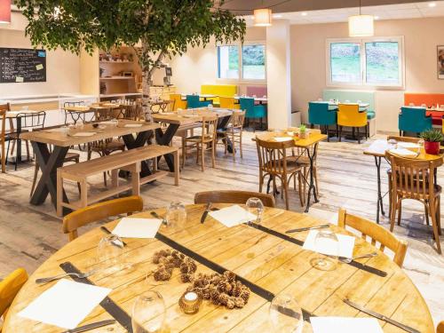 a dining room with wooden tables and chairs at greet Hotel Nancy Sud in Houdemont