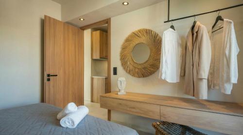 a bedroom with a bed and a mirror and a dresser at NAMA Suites in Hersonissos