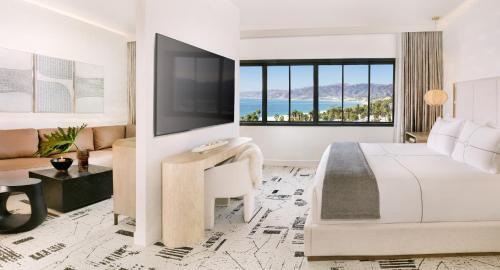 a hotel room with a bed and a desk and a television at Huntley Santa Monica Beach in Los Angeles