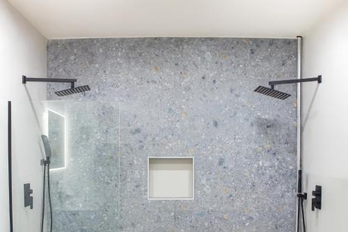 Ocean Park Studio Pool at Riviera Villa في سان خوان: حمام مع دش مع جدار زجاجي