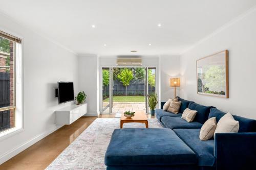 a living room with a blue couch and a tv at Mia's Place Modern Pet friendly Geelong West stay in Geelong West