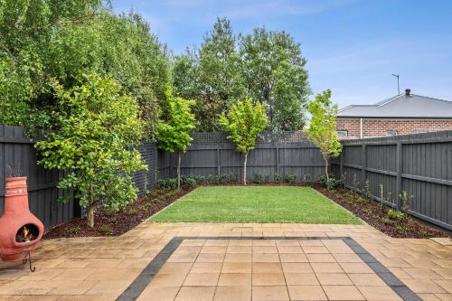 a backyard with a fence and a yard withgrass at Mia's Place Modern Pet friendly Geelong West stay in Geelong West