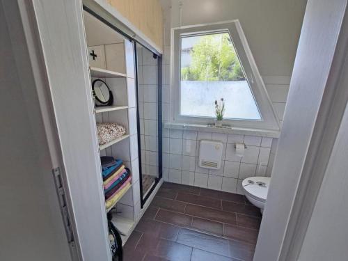 een kleine badkamer met een raam en een toilet bij Moni in Hüttenrode