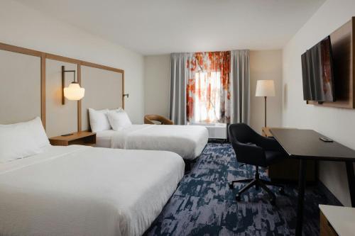 ein Hotelzimmer mit zwei Betten und einem Schreibtisch in der Unterkunft Fairfield Inn and Suites by Marriott Fort Wayne in Fort Wayne