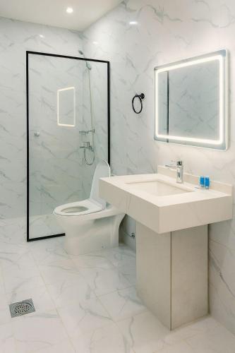 a bathroom with a sink and a toilet and a mirror at فندق الضيافة in Rawkhah