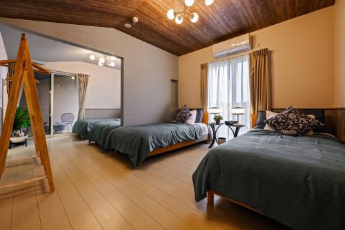 a room with two beds and a mirror in it at 美ら海かふうテラス in Motobu