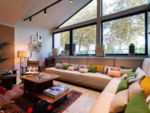 ein Wohnzimmer mit Sofa und Tisch in der Unterkunft Greet Hotel Colmar in Colmar