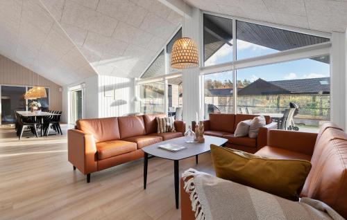 ein Wohnzimmer mit Sofas und einem Tisch in der Unterkunft Cozy Home In Glesborg With Sauna in Fjellerup