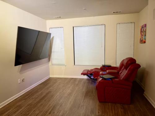 a living room with a red chair and a flat screen tv at Private Room and Bathroom in Revere in Revere