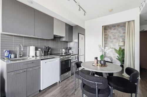 a kitchen with a table and chairs in a room at Bright Downtown Condo with City Views & Comfort in Toronto