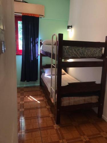 a room with two bunk beds and a window at The Grapevine Hostel in Mendoza