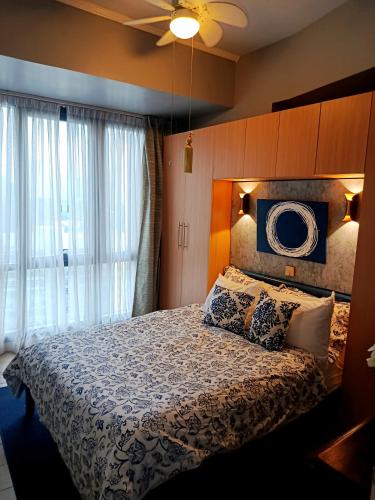 马尼拉McKinley Hills BGC Taguig City Condo的一间卧室，里面有一张床和一个吊扇