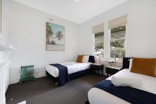 Una habitación de hotel con dos camas y una ventana. en Minty, en Warrnambool