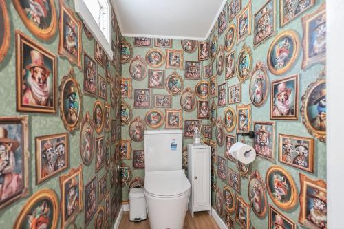 baño con aseo y pared de cuadros en Minty, en Warrnambool