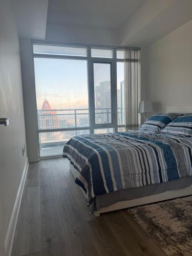 Un dormitorio con una cama y una ventana grande. en The greatest views in the heart of Mississauga, en Mississauga