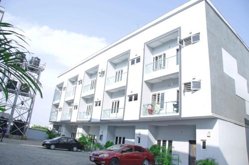 a white building with cars parked in front of it at 2 bedroom Apartment Lekki Ovation Terrace in Lekki