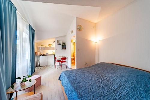 a bedroom with a bed and a table and a kitchen at Studio Trpanj 257c in Trpanj