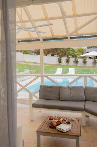 a living room with a couch and a table and a pool at Illaroo House in Shoal Bay