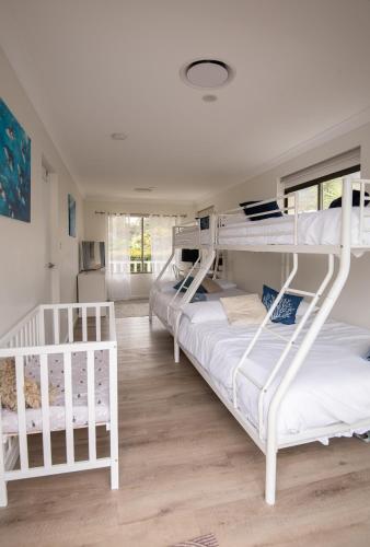 a room with three bunk beds in it at Illaroo House in Shoal Bay