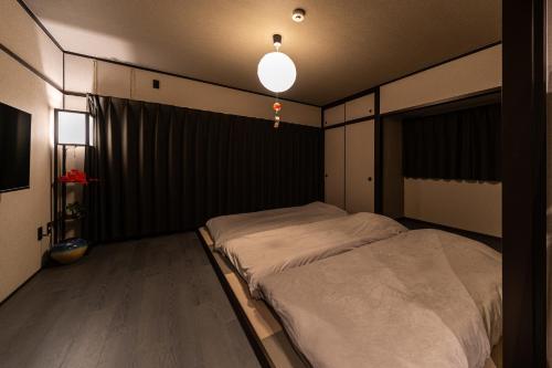 a bedroom with a bed in the corner of a room at おやど紀伊国屋えびす町 in Nagasaki