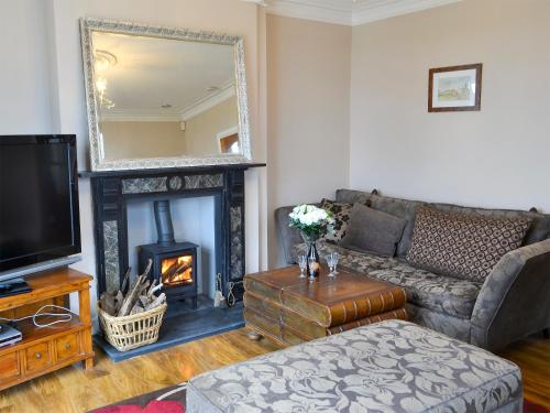 a living room with a couch and a fireplace at The View Old Coastguard Cottage in Tynemouth