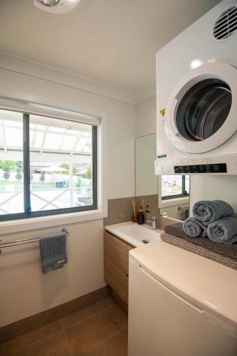 a kitchen with a sink and a microwave at Illaroo House in Shoal Bay
