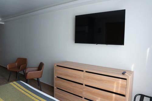 Un dormitorio con un televisor de pantalla plana en una pared. en Hotel Block Suites, en Ciudad de México