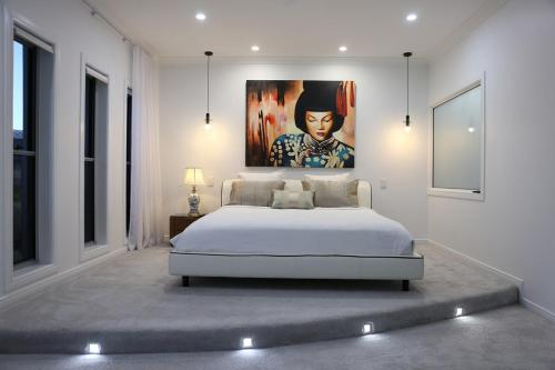 Un dormitorio con una cama con un cuadro en la pared. en Serenade Retreat, At Coomera Waters, Gold Coast, en Gold Coast