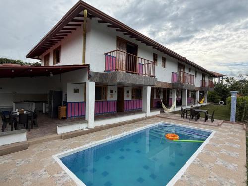 a house with a swimming pool in front of a building at Casa campestre Montenegro Quindio in Montenegro