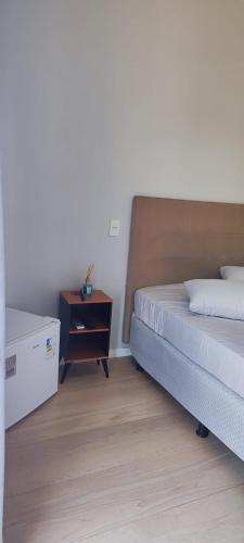 a bedroom with a bed and a dresser with a night stand at Suite Master Bella in São José