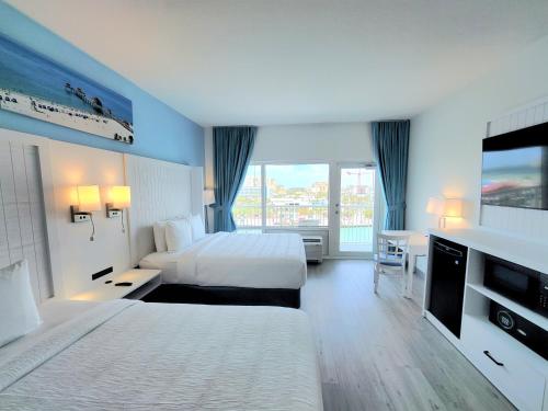 ein Hotelzimmer mit zwei Betten und einem Fernseher in der Unterkunft ChartHouse Clearwater Beach Marina Hotel in Clearwater Beach