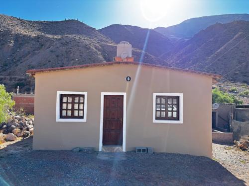 a small house with a mountain in the background at Alojamiento Tati in Purmamarca
