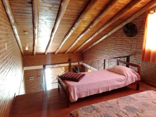 a bedroom with two beds and a wooden ceiling at Aguaribay Cabañas in Arroyo de Los Patos